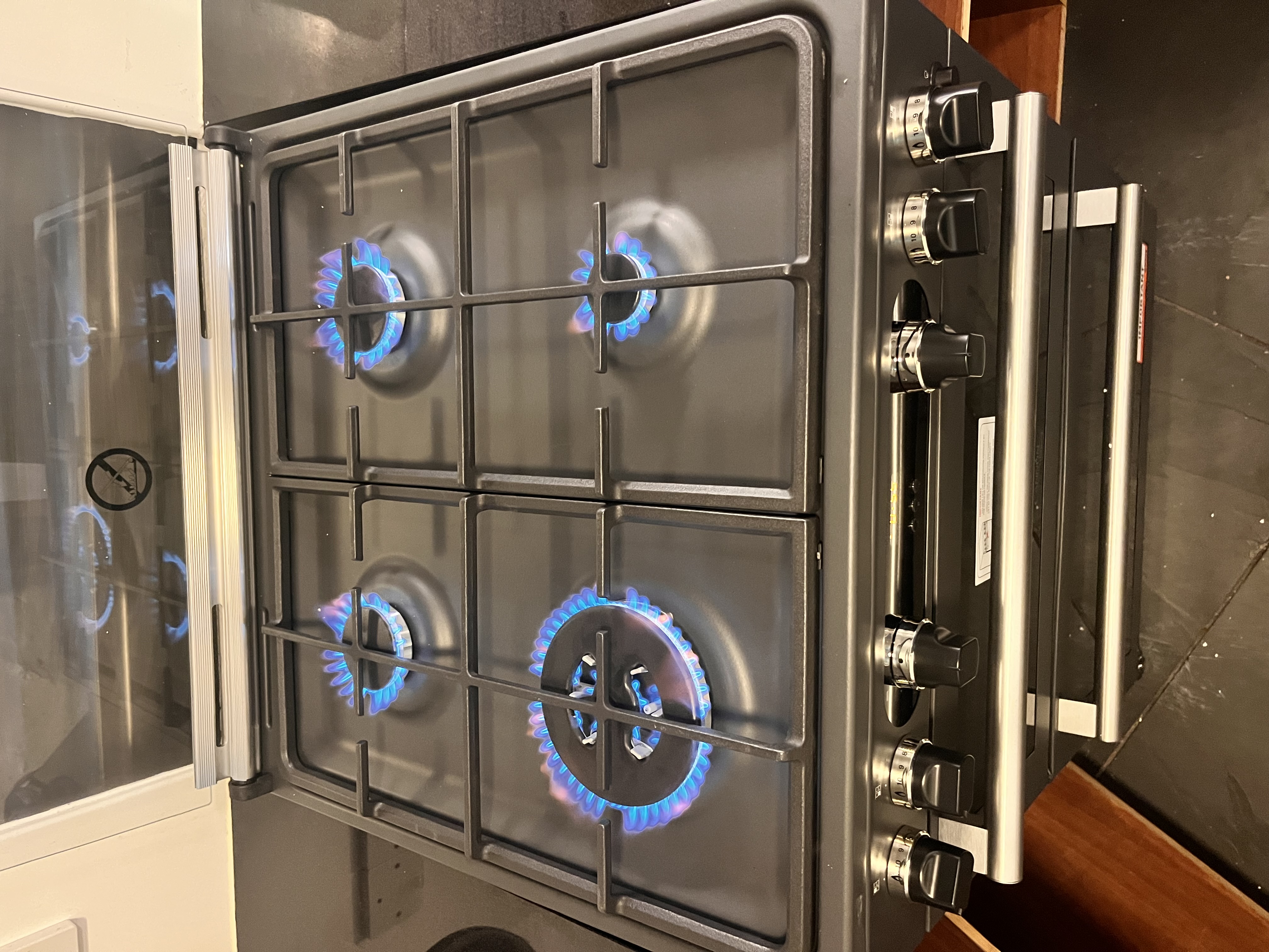 Gas cooker burners lit during appliance safety checks by Pomona Eco Solutions