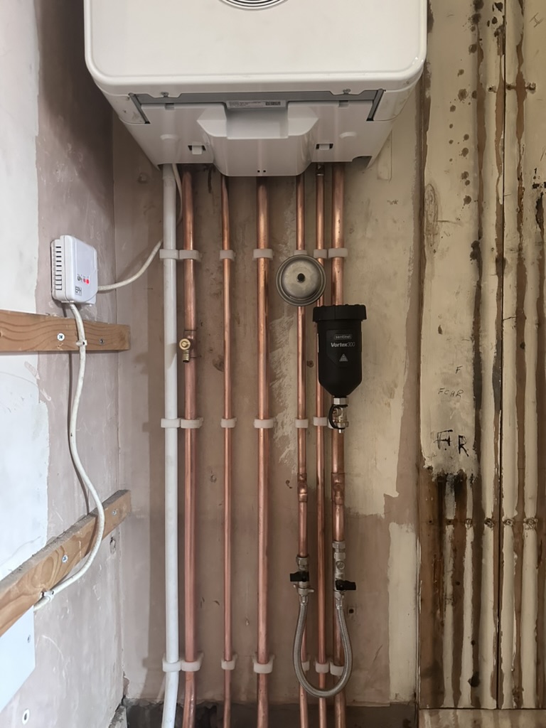 Boiler replacement pipework and magnetic filter fitted neatly beneath the appliance